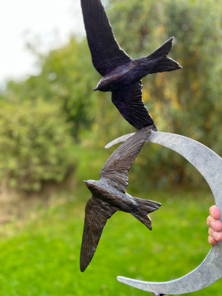 Purple Martin bird sculpture in hand of Joel