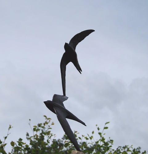 Swift statue set against sky in garden